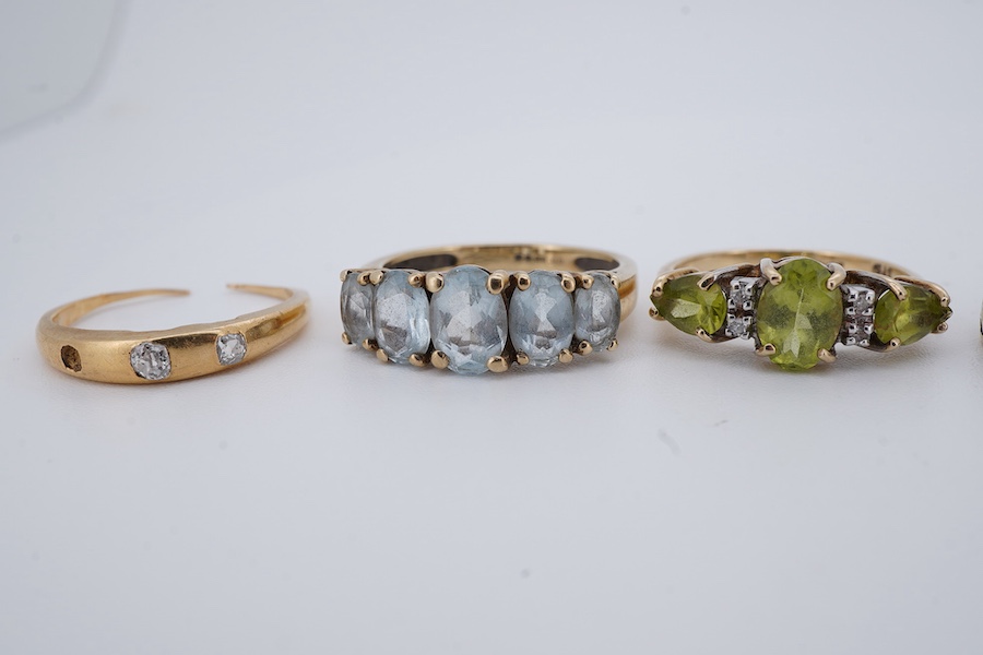 Five rings, comprising: a peridot and diamond ring and a blue topaz ring, each mounted in 9ct gold, sizes J and K1/2; gross weight approximately 3.5 grams; a gold ring set with cushion-shaped diamonds, shank broken, one